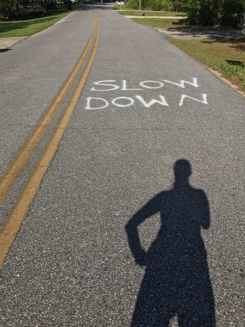 slow down runner's shadow on road
